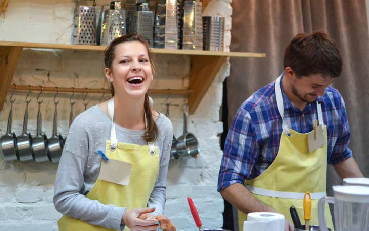 Нappy man and woman cooking and talking in the kitchen